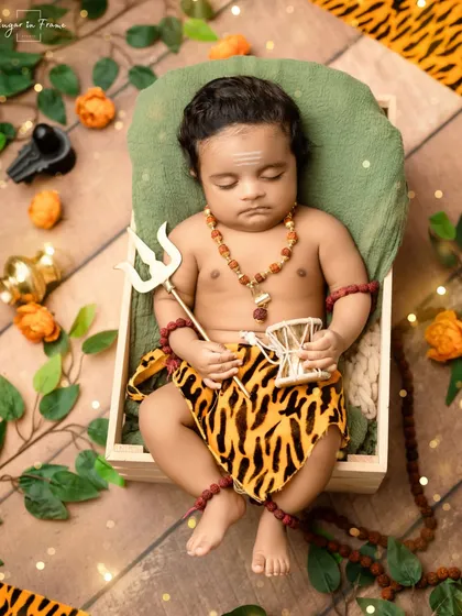 A full-length view of our 'Little Mahadev' setup, with the baby peacefully sleeping in a wooden crate surrounded by props.