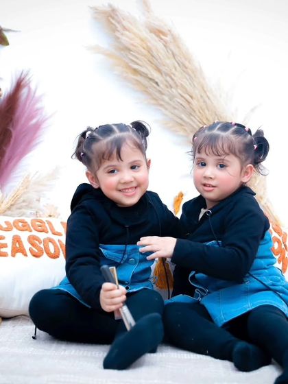 A sweet moment between two sisters in matching outfits. We love capturing the bond between siblings.