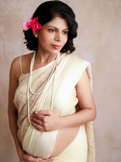 A pensive, beautiful portrait of an expecting mother. Her hand rests on her belly, a gesture full of love and a heart full of anticipation for the little one inside.