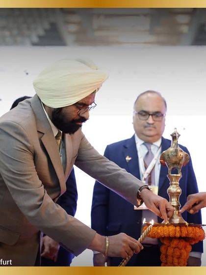 A dignitary lights the ceremonial lamp, officially kicking off three days of innovation and business.