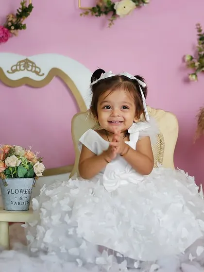 A princess in her castle. This setup features a pink and gold theme with a carriage frame, flowers, and fluffy clouds for a magical fairytale photoshoot.
