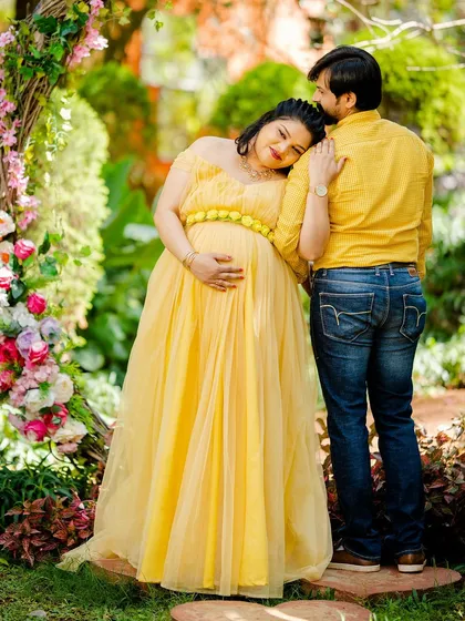 A tender and candid moment between an expecting couple in a vibrant garden. The soft natural light and genuine interaction are what make these couple maternity sessions so special.