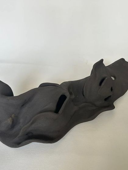 An abstract, hand-built sculpture with flowing lines and organic openings. I love how the dark clay gives it a powerful, mysterious feel.