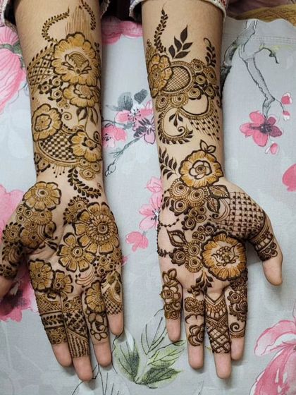 A full and lush floral design covering the hands and wrists. The shading inside the flowers gives them depth and makes the pattern look very rich.
