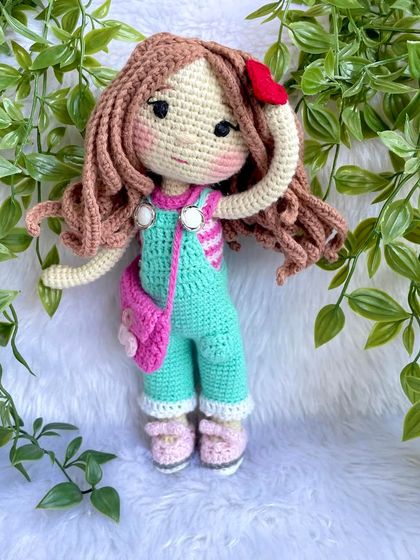 This is the same doll in her second outfit! This set includes mint green overalls, a pink floral bag, and a cute red hair clip. Having multiple outfits makes playtime even more exciting.