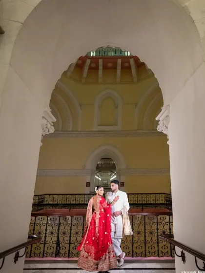 A wide-angle shot using the grand staircase and dome to frame the couple. This architectural portrait adds a sense of scale and drama.