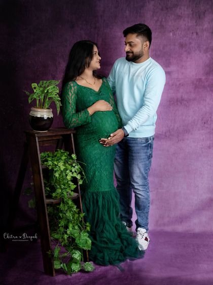 A beautiful couple's portrait using rustic props like a ladder and greenery to complement her emerald gown.