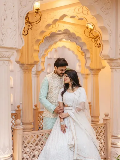 An elegant pre-wedding look in traditional attire. The makeup is soft and glowing, complementing the beautiful white and pastel outfits.