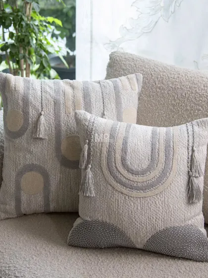 The Contours Cushion Collection adds artisanal character to any sofa. Inspired by the elegance of geometry, these cushions feature modern designs in a soothing palette of grey, white, and beige, with refined details like tafting work and tassels.