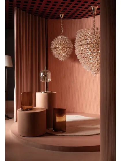 A dedicated display for statement chandeliers. The curved alcove and high-contrast ceiling grid draw attention to these intricate fixtures, presenting them as pieces of art.