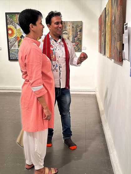 Explaining the details of my paintings to a visitor at an art exhibition.