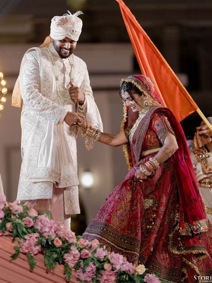 A joyful moment during the ceremony as the groom helps the bride, both of them smiling.
