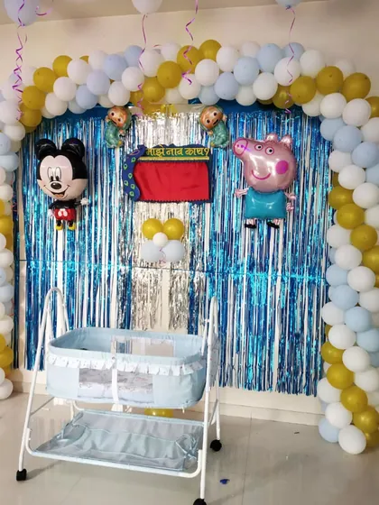 A closer look at the naming ceremony cradle setup with Mickey Mouse and Peppa Pig foil balloons.
