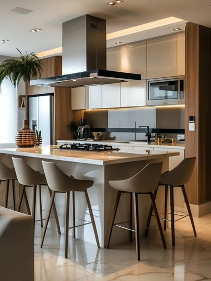 A modern open-plan kitchen with a large central island that doubles as a breakfast bar. The design combines white and wood-tone cabinets with a sleek chimney hood, perfect for social cooking and entertaining.