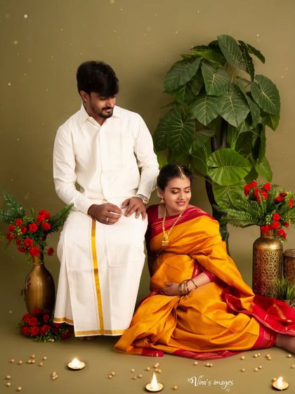 A loving gaze shared between the couple in their traditional outfits. This shot focuses on their relationship and the shared joy of expecting a child.