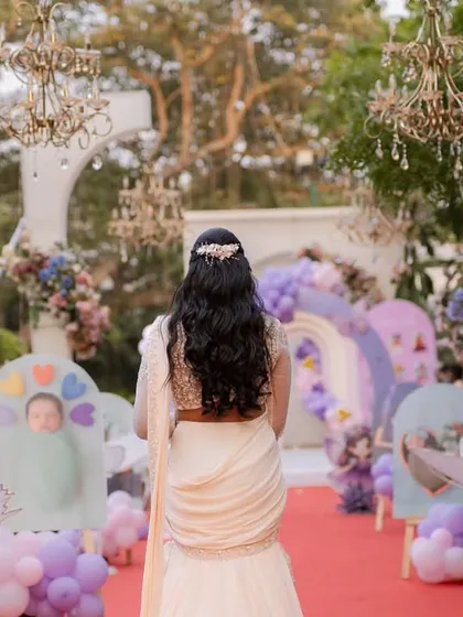 A guest's view walking into Varnnika's fairyland birthday. The path is lined with pastel-colored decor and floral arrangements, with elegant chandeliers overhead, creating a truly enchanting entrance.