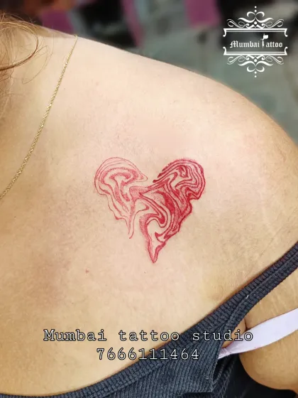 A unique red ink tattoo of a heart with a marbled, liquid effect.
