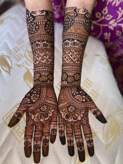 A gorgeous full-arm design featuring peacocks at the top, surrounded by intricate floral and geometric patterns.