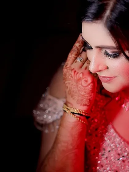 A dramatic close-up portrait of the bride with a red light effect. This creative lighting adds a modern and artistic touch to the photo.