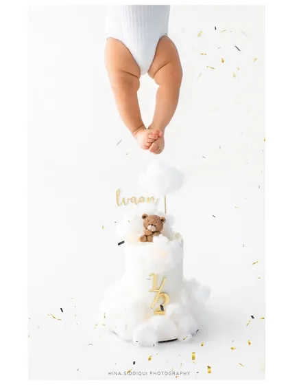 A duplicate of the creative half birthday cake shot, emphasizing its artistic appeal. This type of conceptual photography adds a unique touch to your baby's gallery.