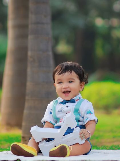 A happy baby boy enjoying the fresh air during his outdoor photoshoot. We use simple props and the beauty of nature to create delightful children's portraits.