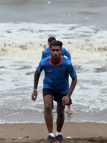 The intense focus of a player during a beach running drill. This kind of conditioning builds the explosive speed needed to save crucial runs in a match.