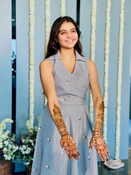 A smiling shot of the client, proudly displaying her personalized henna.
