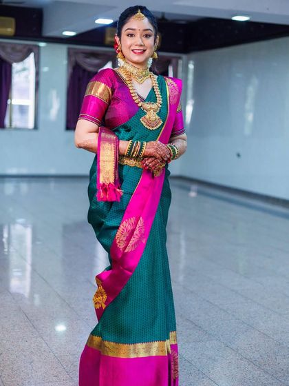 A change of saree for the same bride, now in a deep teal and pink Kanjivaram. This shows how we can create multiple distinct looks for different ceremonies on the same day.