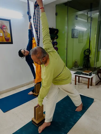 Here, students use blocks and ropes for support in Utthita Trikonasana (Extended Triangle Pose). Props are not a crutch; they are tools that teach us the correct alignment and action in a pose.