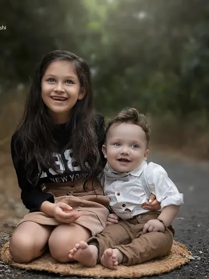 Big sister's pride and baby brother's joy. This outdoor sibling portrait perfectly captures the special relationship between them.