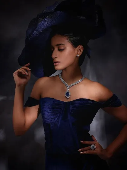 An elegant portrait for Purab Paschim, featuring a statement blue sapphire pendant necklace, styled with a dramatic blue hat.