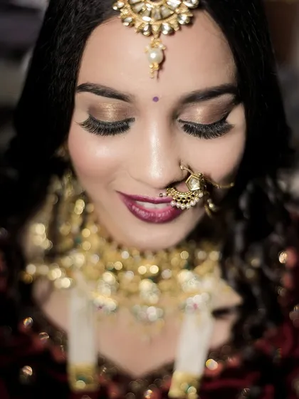 A delicate close-up focusing on the bride's stunning eye makeup and jewelry. This shot highlights the artistry of her bridal look, from her long lashes to her shimmering eyeshadow.