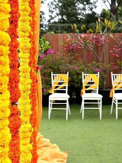 A close-up of the vibrant marigold garlands used in a traditional Haldi decor setup, adding a pop of color and fragrance.