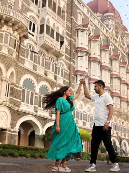 We use iconic locations like Mumbai's Taj Mahal Palace Hotel to create dramatic and memorable pre-wedding photographs. This shot captures a dynamic, joyful dance, turning a city landmark into a personal part of your story.