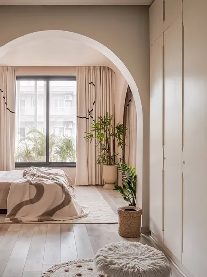 An archway frames the view into the bedroom, showcasing the layered design and the seamless flow from the wardrobe area to the sleeping space.