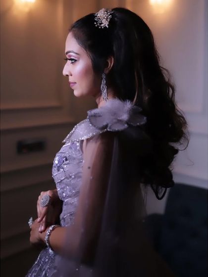 A side profile of the lilac ball gown, highlighting the delicate floral appliqué on the shoulder and the attached sheer cape. These small details add a layer of sophistication to the overall design.