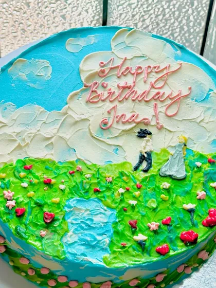 Another view of our hand-painted countryside love story cake. The texture of the clouds and grassy fields is created with careful palette knife work.