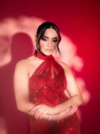 This image from a jewelry campaign captures a look of modern glamour. The red halter gown and sparkling diamond earrings are styled to create a powerful and confident statement, perfect for a luxury brand.
