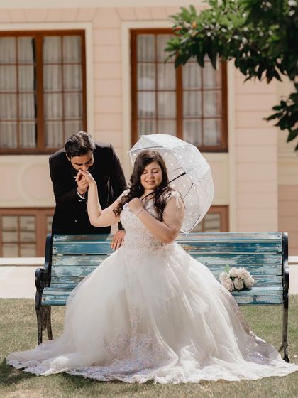 A fairytale moment with the groom kissing his bride's hand. The flowing white gown and the garden setting make this a truly romantic pre-wedding picture.