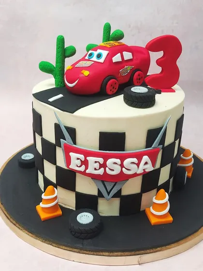 This McQueen Car Cake puts the star racer front and center on a road, complete with desert cacti, tires, and traffic cones for a full racing scene.