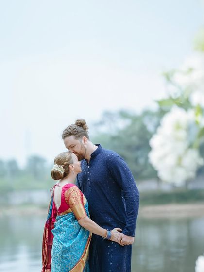A tender moment between a couple dressed in traditional South Indian attire by a serene lake. This photo beautifully blends cultural elegance with natural scenery.