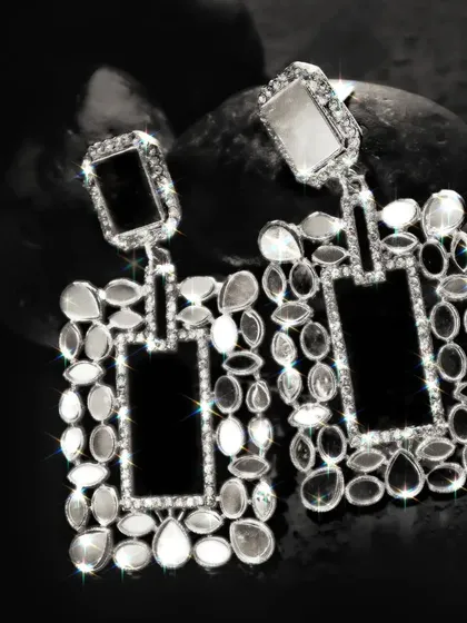 A high-contrast black and white image of the statement earrings, where the sparkle effect is enhanced to create a glamorous, eye-catching look.