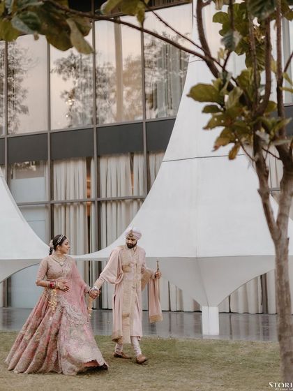 Sagar and Riya walking together after their ceremony, framed by the modern architecture of the venue.