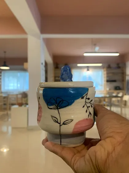 A hand-painted lidded jar with a delicate floral design. This piece shows a wonderful combination of form and surface decoration.