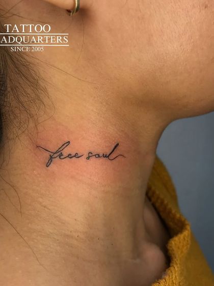 The words "free soul" in a fine, flowing script tattooed on the neck, a declaration of independence and spirit.