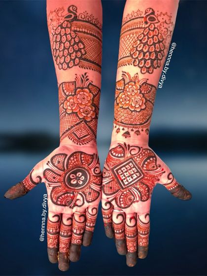 A striking design with bold floral mandalas on the palms and elegant peacocks on the forearms. The use of negative space makes the motifs stand out.