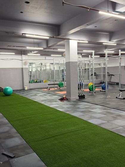 An integrated training environment with a turf track running alongside the main gym floor. This allows us to combine strength exercises with speed and agility drills, creating a comprehensive athletic development session.