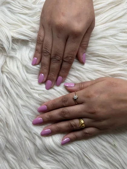 A simple yet beautiful set of almond-shaped nail extensions with a solid lavender gel polish.