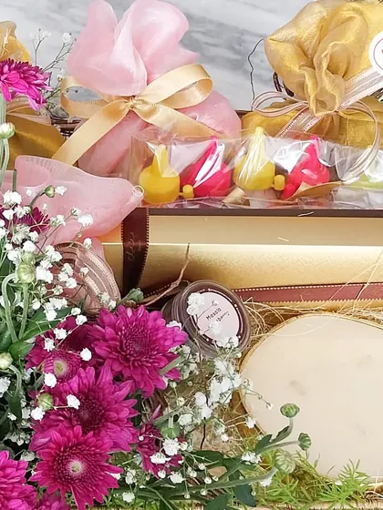 A close-up of the festive hamper, showing the diya-shaped chocolates and scented candle.