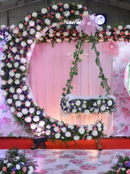 I love making naming ceremonies magical. This moon-shaped cradle design, adorned with a cascade of fresh flowers against a floral print backdrop, creates a dreamy setting to welcome a new baby.